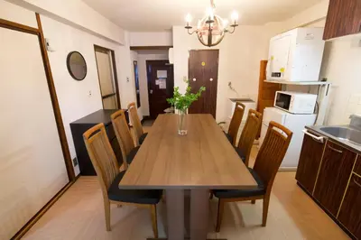 a kitchen and dining room with a wooden table and chairs at \u9daf\u8c37 \u5bdb\u6c38\u5bfa\u5742\u30cf\u30a4\u30e0902 in Tokyo