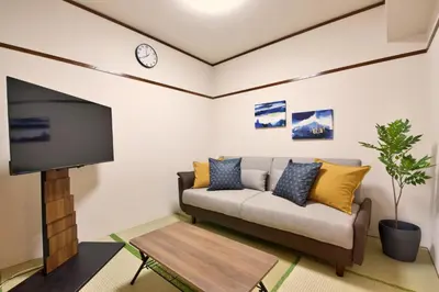 a living room with a couch and a tv at \u9daf\u8c37 \u5bdb\u6c38\u5bfa\u5742\u30cf\u30a4\u30e0902 in Tokyo