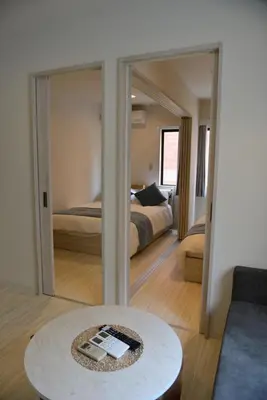 a room with a bed and a table and a mirror at SKY inn 1F in Tokyo