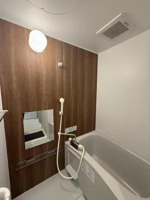 a bathroom with a bath tub and a mirror at SKY inn 1F in Tokyo