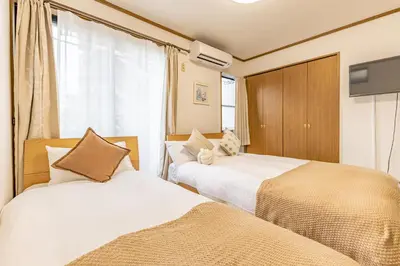 a bedroom with two beds and a tv in it at Nishiikebukuro 3people, mansion,2 mins to subway in Tokyo