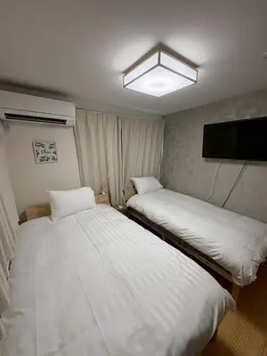 two beds in a small room with a tv at \u3055\u304f\u3089\u65c5\u9928\u9ad8\u5186\u5bfa\u5317\u5343\u5229\u4f11102\u53f7\u5ba4 in Tokyo