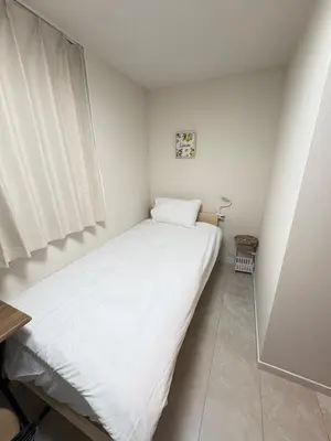 a small bedroom with a large white bed in it at \u3055\u304f\u3089\u65c5\u9928\u9ad8\u5186\u5bfa\u5317\u5343\u5229\u4f11102\u53f7\u5ba4 in Tokyo