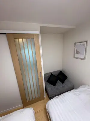 a bedroom with a door leading to a bed at \u3055\u304f\u3089\u65c5\u9928\u9ad8\u5186\u5bfa\u5317\u5343\u5229\u4f11102\u53f7\u5ba4 in Tokyo