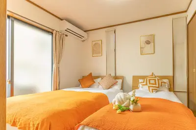 two beds in a room with orange sheets at Nishiikebukuro 4people, 2mins to subway in Tokyo