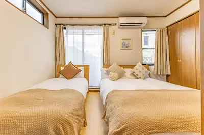 two beds in a small room with a window at Nishiikebukuro 4people, 2mins to subway in Tokyo