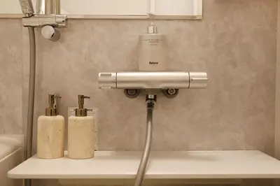 a bathroom sink with two soap dispensers on it at Shibuya house w Rooftop, 6min to Station, Skyline View in Tokyo