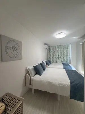 a bedroom with a large bed with blue pillows at SKY inn 2-3F in Tokyo