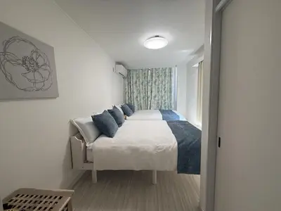 a bedroom with a bed with blue pillows at SKY inn 2-3F in Tokyo