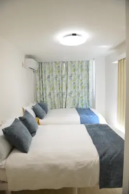 a bedroom with two beds and a window at SKY inn 2-3F in Tokyo