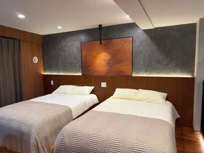 two beds are in a room with a wall at A3 Shinjuku Business District hotel, 9 mins to ST Max 4P \u65b0\u5bbf\u5546\u52a1\u533a \u5168\u65b0\u88c5\u4fee \u4ea4\u901a\u4e2d\u5fc3 \u8f66\u7ad99\u5206\u949f \u6700\u59274\u4eba \u76f4\u8fbe\u65b0\u5bbf \u6d89\u8c37 \u8868\u53c2\u9053 \u54c1\u5ddd \u6c60\u888b \u4e0a\u91ce \u4ee3\u4ee3\u6728 \u94f6\u5ea7 \u539f\u5bbf in Tokyo