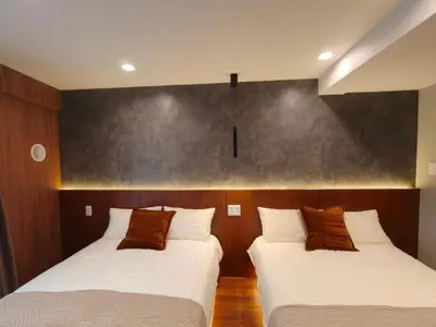 two beds in a room with wooden walls at D3 Shinjuku Business District hotel, 9 mins to ST Max 4P \u65b0\u5bbf\u5546\u52a1\u533a \u5168\u65b0\u88c5\u4fee \u4ea4\u901a\u4e2d\u5fc3 \u8f66\u7ad99\u5206\u949f \u6700\u59274\u4eba \u76f4\u8fbe\u65b0\u5bbf \u6d89\u8c37 \u8868\u53c2\u9053 \u54c1\u5ddd \u6c60\u888b \u4e0a\u91ce \u4ee3\u4ee3\u6728 \u94f6\u5ea7 \u539f\u5bbf in Tokyo