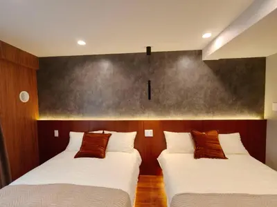 two beds are in a room with aintendent at B2 Shinjuku Business District hotel, 9 mins to ST Max 4P \u65b0\u5bbf\u5546\u52a1\u533a \u5168\u65b0\u88c5\u4fee \u4ea4\u901a\u4e2d\u5fc3 \u8f66\u7ad99\u5206\u949f \u6700\u59274\u4eba \u76f4\u8fbe\u65b0\u5bbf \u6d89\u8c37 \u8868\u53c2\u9053 \u54c1\u5ddd \u6c60\u888b \u4e0a\u91ce \u4ee3\u4ee3\u6728 \u94f6\u5ea7 \u539f\u5bbf in Tokyo