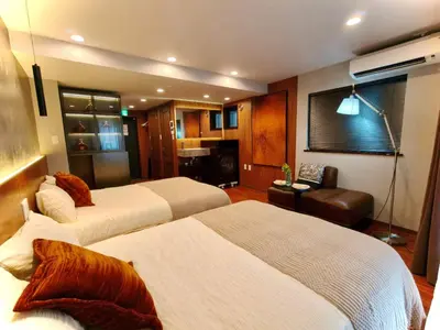 a hotel room with two beds and a couch at A1 Shinjuku Business District hotel, 9 mins to ST Max 4P \u65b0\u5bbf\u5546\u52a1\u533a \u5168\u65b0\u88c5\u4fee \u4ea4\u901a\u4e2d\u5fc3 \u8f66\u7ad99\u5206\u949f \u6700\u59274\u4eba \u76f4\u8fbe\u65b0\u5bbf \u6d89\u8c37 \u8868\u53c2\u9053 \u54c1\u5ddd \u6c60\u888b \u4e0a\u91ce \u4ee3\u4ee3\u6728 \u94f6\u5ea7 \u539f\u5bbf in Tokyo