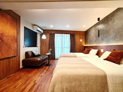 a hotel room with two beds and a chair at A1 Shinjuku Business District hotel, 9 mins to ST Max 4P \u65b0\u5bbf\u5546\u52a1\u533a \u5168\u65b0\u88c5\u4fee \u4ea4\u901a\u4e2d\u5fc3 \u8f66\u7ad99\u5206\u949f \u6700\u59274\u4eba \u76f4\u8fbe\u65b0\u5bbf \u6d89\u8c37 \u8868\u53c2\u9053 \u54c1\u5ddd \u6c60\u888b \u4e0a\u91ce \u4ee3\u4ee3\u6728 \u94f6\u5ea7 \u539f\u5bbf in Tokyo