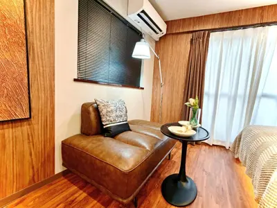 a living room with a leather couch and a table at A1 Shinjuku Business District hotel, 9 mins to ST Max 4P \u65b0\u5bbf\u5546\u52a1\u533a \u5168\u65b0\u88c5\u4fee \u4ea4\u901a\u4e2d\u5fc3 \u8f66\u7ad99\u5206\u949f \u6700\u59274\u4eba \u76f4\u8fbe\u65b0\u5bbf \u6d89\u8c37 \u8868\u53c2\u9053 \u54c1\u5ddd \u6c60\u888b \u4e0a\u91ce \u4ee3\u4ee3\u6728 \u94f6\u5ea7 \u539f\u5bbf in Tokyo