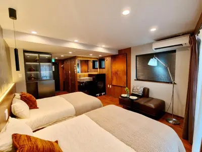 a hotel room with two beds and a couch at A1 Shinjuku Business District hotel, 9 mins to ST Max 4P \u65b0\u5bbf\u5546\u52a1\u533a \u5168\u65b0\u88c5\u4fee \u4ea4\u901a\u4e2d\u5fc3 \u8f66\u7ad99\u5206\u949f \u6700\u59274\u4eba \u76f4\u8fbe\u65b0\u5bbf \u6d89\u8c37 \u8868\u53c2\u9053 \u54c1\u5ddd \u6c60\u888b \u4e0a\u91ce \u4ee3\u4ee3\u6728 \u94f6\u5ea7 \u539f\u5bbf in Tokyo