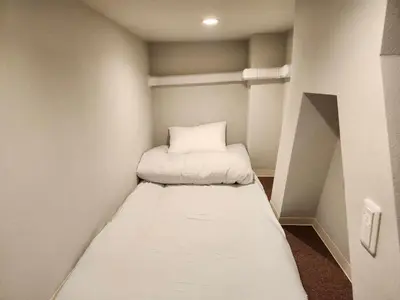 a small room with a bed in the corner at Ark Hills Haneda Inn in Tokyo