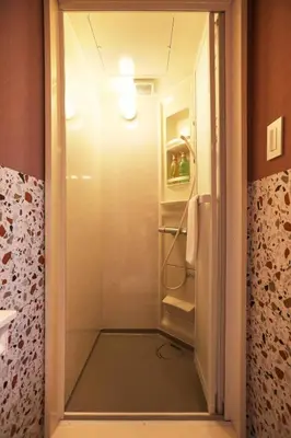 a bathroom with a glass door to a walk in shower at the Moto Hotel Ueno II in Tokyo