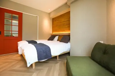 a bedroom with a large bed and a couch at the Moto Hotel Ueno II in Tokyo
