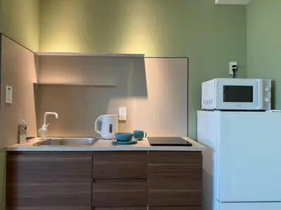 a kitchen with a sink and a white refrigerator at the Moto Hotel Ueno II in Tokyo