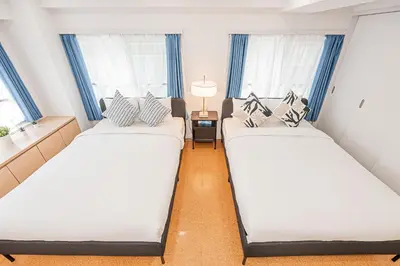 two beds in a small room with windows at phoneix apt ginza in Tokyo