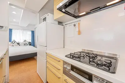 a kitchen with a stove top oven next to a bed at phoneix apt ginza in Tokyo