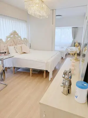 a white bedroom with two beds and a chandelier at ReimiMondo 1107 in Tokyo