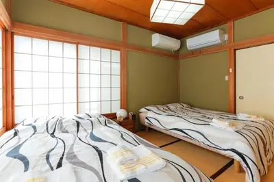 two beds in a room with two windows at \u897f\u65b0\u5bbf\u548c\u5eb5 wa-an homestay in Tokyo