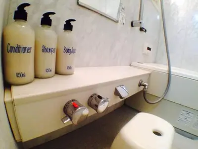 a bathroom with three bottles on a shelf next to a toilet at \u897f\u65b0\u5bbf\u548c\u5eb5 wa-an homestay in Tokyo