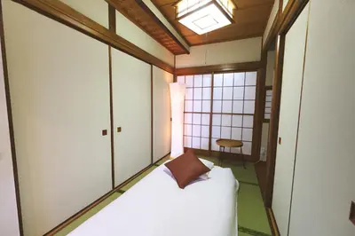 a room with a bed with a pillow on it at \u96fb\u8eca\u3067\u65b0\u5bbf\u307e\u306710\u52063ldk2\u500b\u30c8\u30a4\u30ec2\u500b\u30b7\u30e3\u30ef\u30fc\u5ba4\u7121\u6599\u99d0\u8eca\u5834\u5ead\u4ed8\u304d in Tokyo