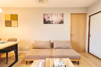 a living room with a couch and a table at \u96fb\u8eca\u3067\u65b0\u5bbf\u307e\u306710\u52063ldk2\u500b\u30c8\u30a4\u30ec2\u500b\u30b7\u30e3\u30ef\u30fc\u5ba4\u7121\u6599\u99d0\u8eca\u5834\u5ead\u4ed8\u304d in Tokyo