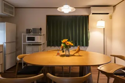 a kitchen with a table with a vase of flowers on it at Kotori Ikebukuro in Tokyo