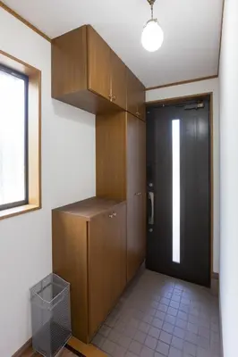 a kitchen with wooden cabinets and a door at Kotori Ikebukuro in Tokyo