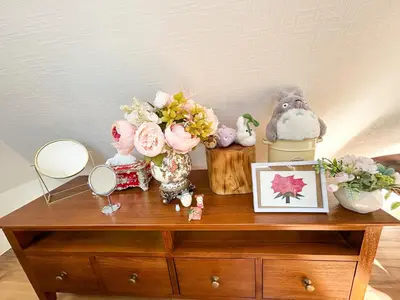 a wooden dresser with flowers and other items on it at Fuji Hotel Tokyo Takadanobaba2 in Tokyo