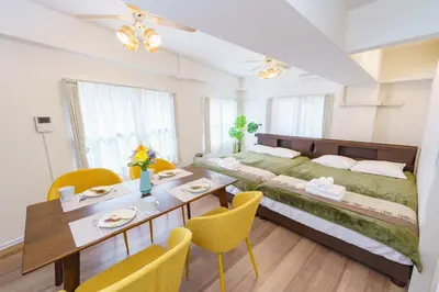 a bedroom with a large bed and a dining table at feel Shinjuku STAY in Tokyo