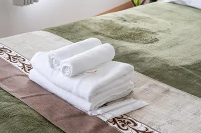 two white towels sitting on top of a bed at feel Shinjuku STAY in Tokyo