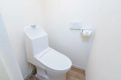 a white toilet in a bathroom with a clock on the wall at feel Shinjuku STAY in Tokyo