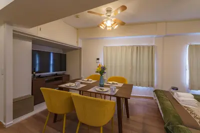 a dining room with a table and yellow chairs at feel Shinjuku STAY in Tokyo