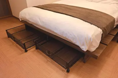 a bed with two trays under it on a wooden floor at Senjushuku FUJI 101 \u5317\u5343\u4f4f in Tokyo
