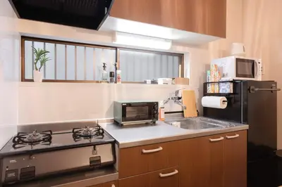 a small kitchen with a stove and a sink at Senjushuku FUJI 101 \u5317\u5343\u4f4f in Tokyo