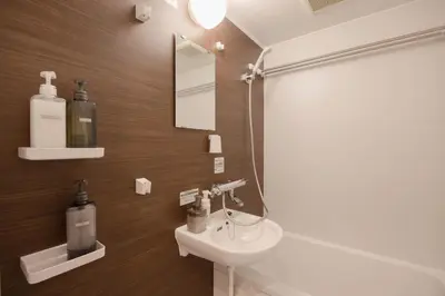a bathroom with a sink and a toilet and a mirror at Senjushuku FUJI 101 \u5317\u5343\u4f4f in Tokyo