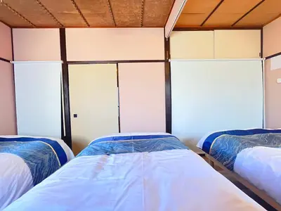 two beds in a room with three windows at Nakakasai Kodate NKK21 in Tokyo