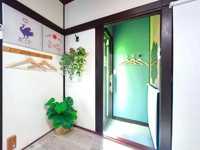 a hallway with a green door and a plant at Nakakasai Kodate NKK21 in Tokyo