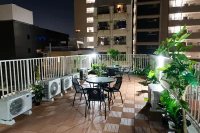 a patio with tables and chairs on a balcony at night at 3 minutes to Shinjuku by subway-Nakanokaikan II in Tokyo