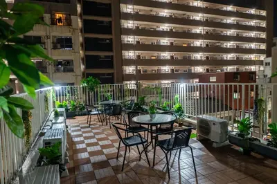 a balcony with tables and chairs and a building at 3 minutes to Shinjuku by subway-Nakanokaikan II in Tokyo