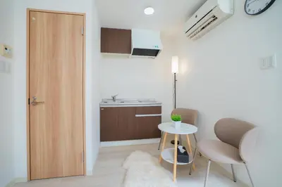 a room with a table and two chairs and a kitchen at 3 minutes to Shinjuku by subway-Nakanokaikan II in Tokyo