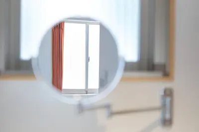 a mirror on the wall of a bathroom at Liberty Place Nakano by Tranova in Tokyo