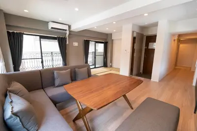 a living room with a couch and a wooden table at VOERE亀戸 - Kameido Modern Suite - Direct to Akihabara & Shinjuku - Near Asakusa, Skytree in Tokyo