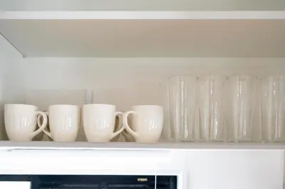 a row of white cups and vases sitting on a shelf at VOERE亀戸 - Kameido Modern Suite - Direct to Akihabara & Shinjuku - Near Asakusa, Skytree in Tokyo